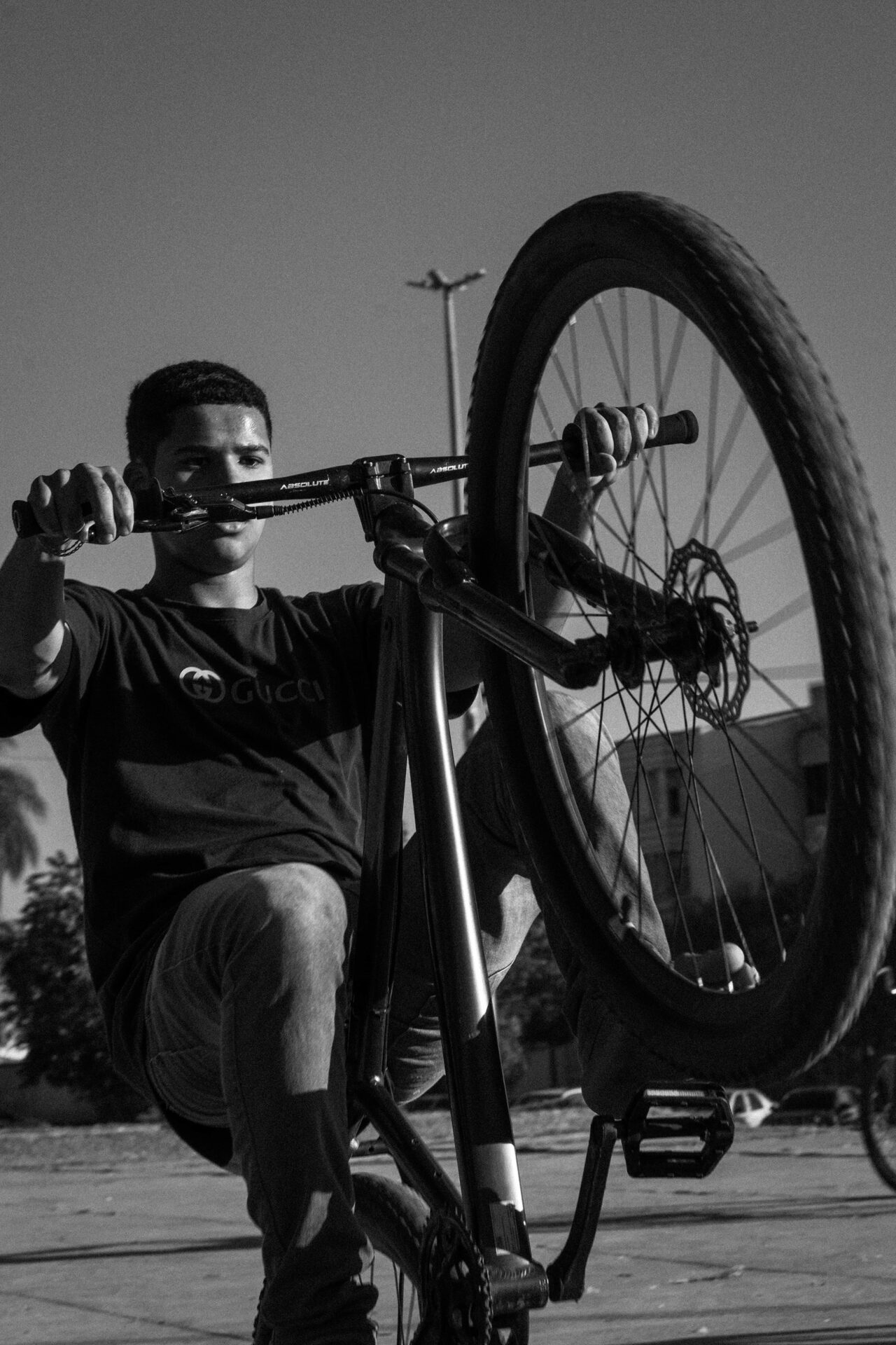 Homem fazendo manutenção na bicicleta, foto preto e branco
