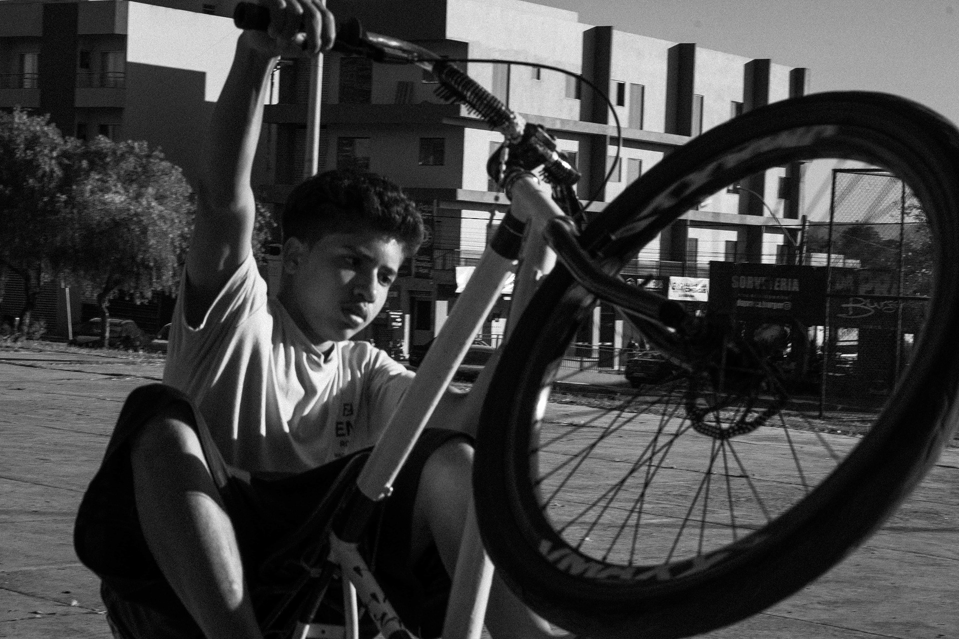 Homem ajustando componentes da bicicleta, foto preto e branco