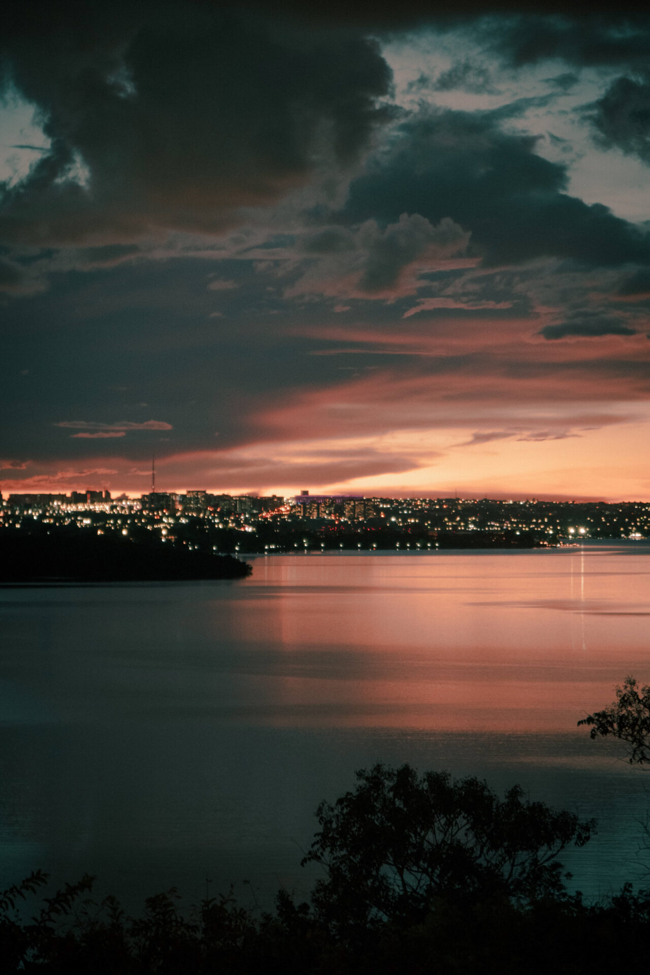 Vista aérea de floresta e lago com céu colorido ao pôr do sol