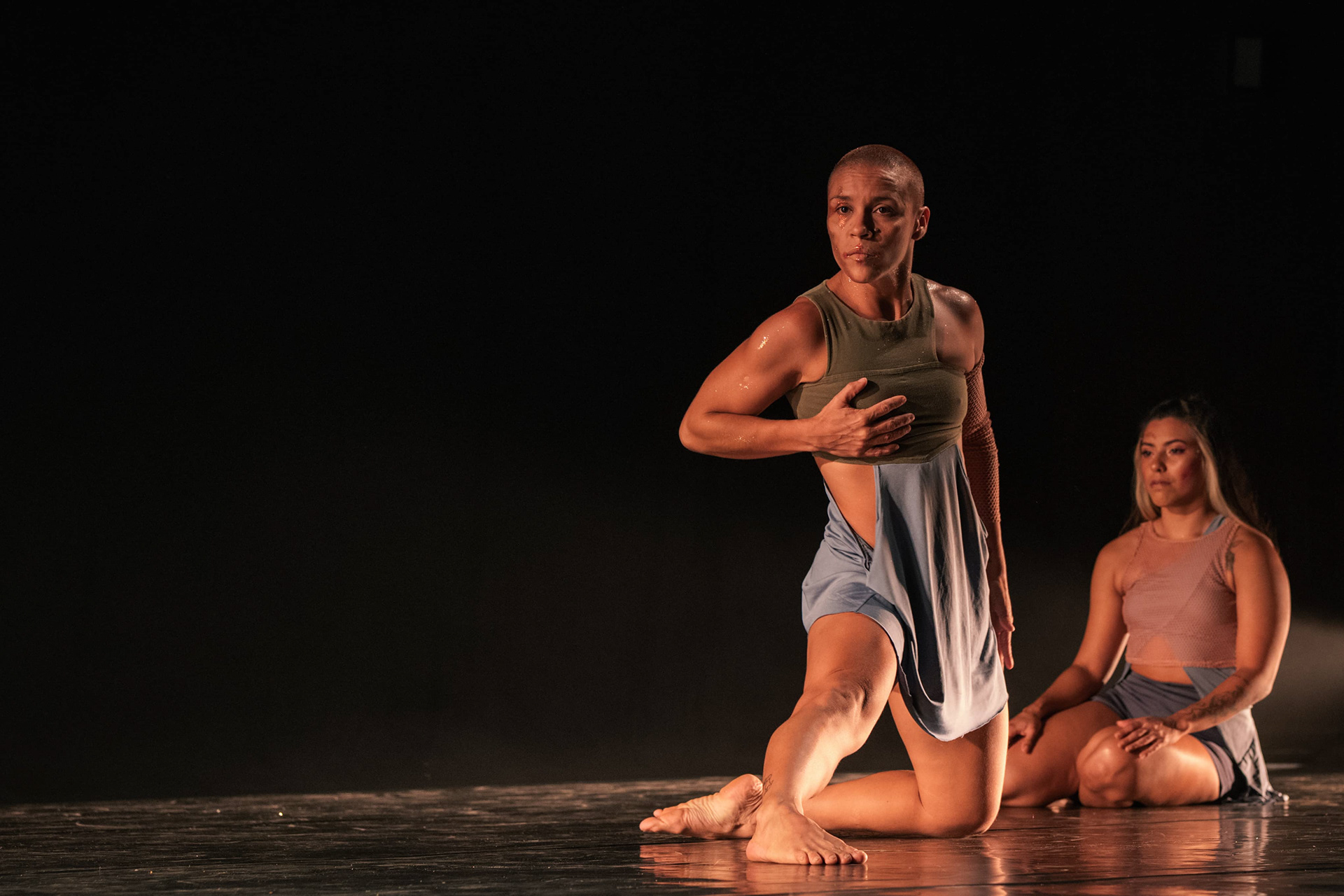 Bailarina em salto durante espetáculo de dança em palco escuro