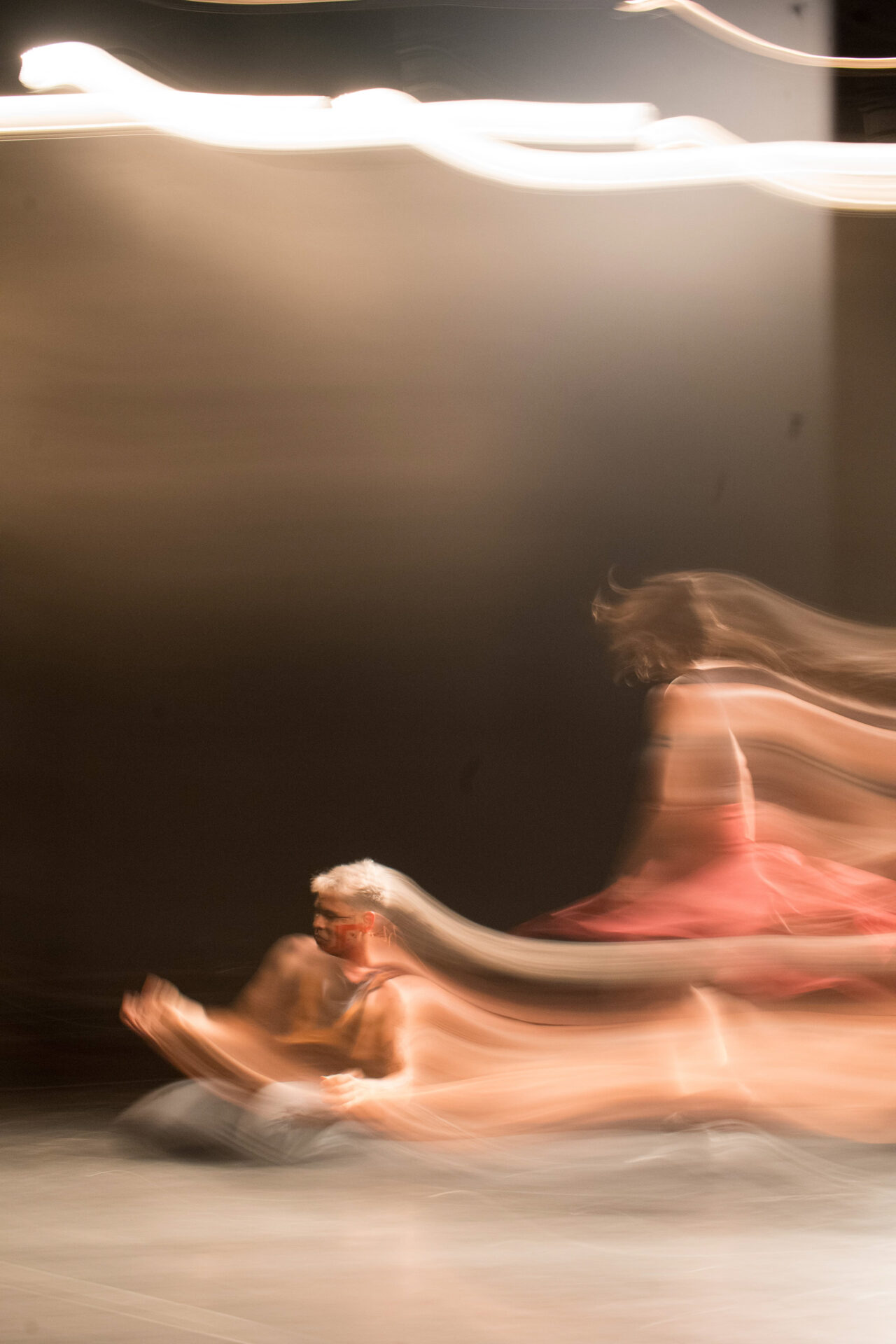 Bailarino solo em palco escuro durante apresentação