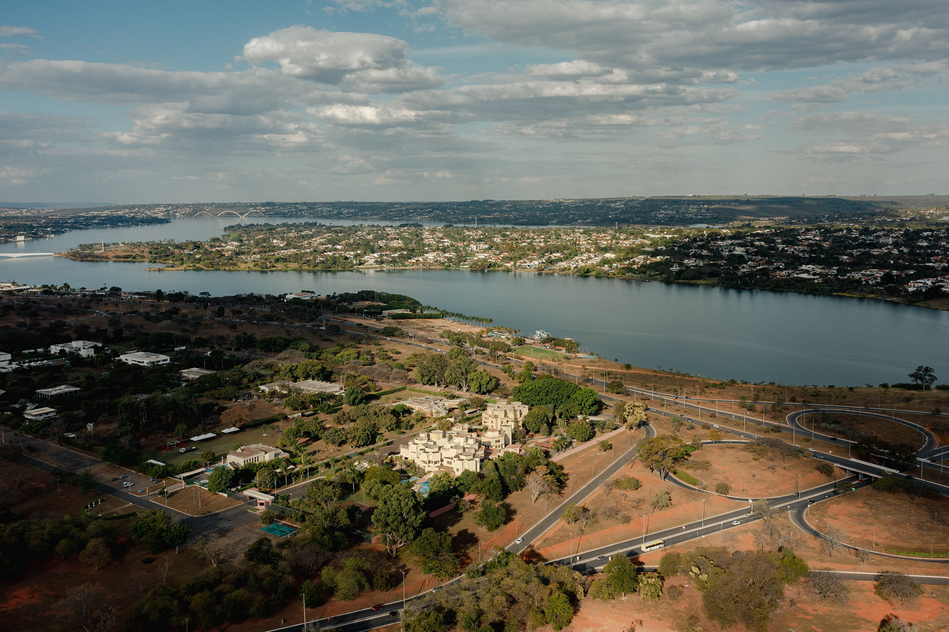 Vista aérea da curva do Lago Paranoá com a cidade ao fundo, Brasília