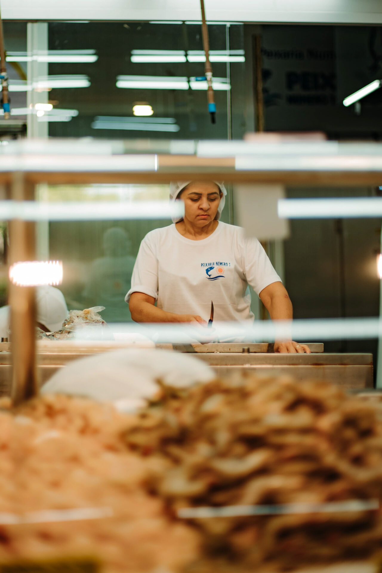 Feirante manuseando tecidos em barraca de roupas