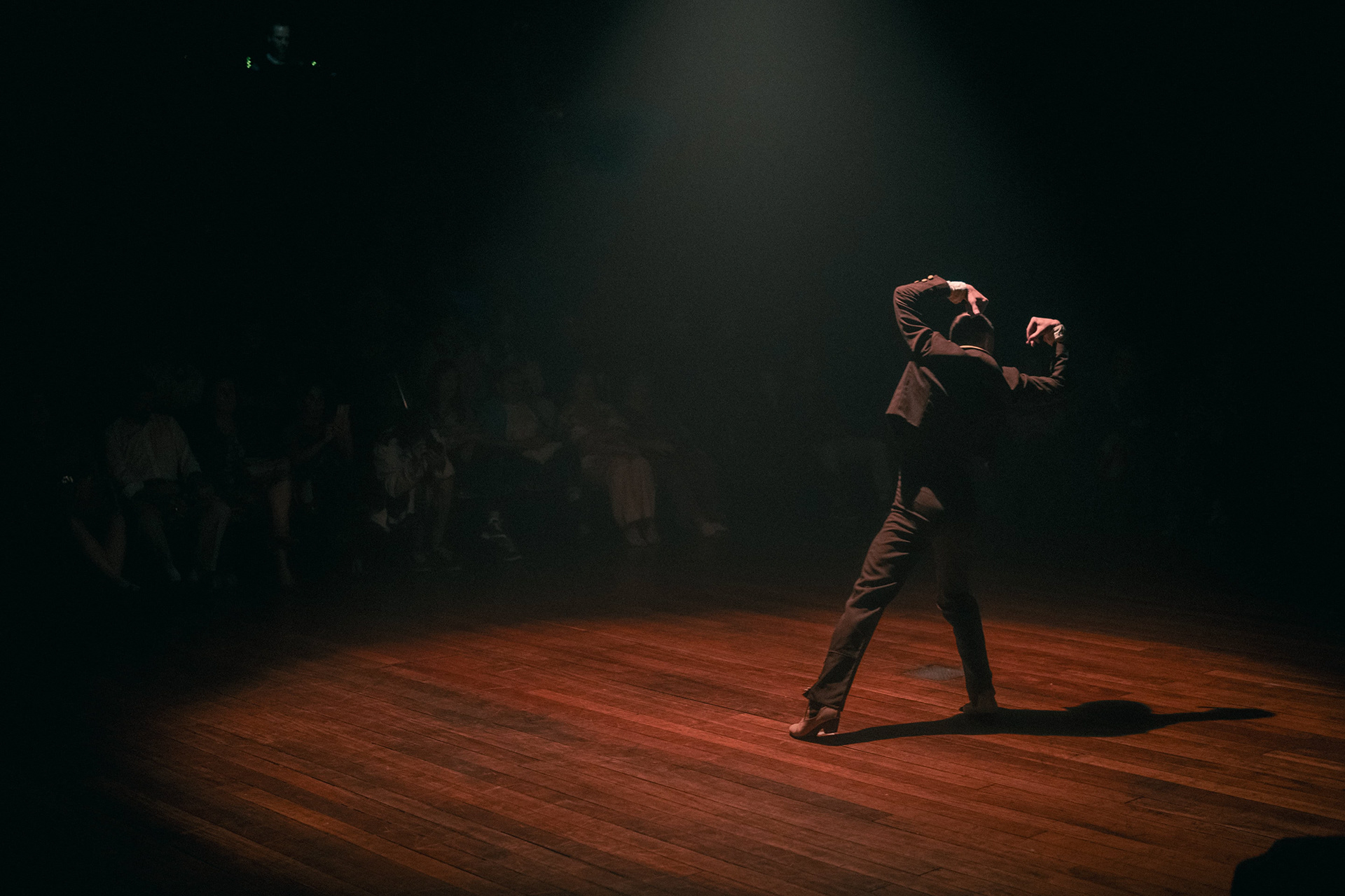 Bailarina de flamenco iluminada em palco escuro