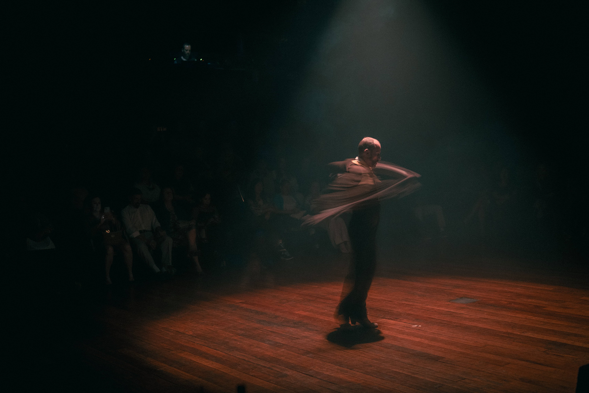 Bailarino de flamenco em movimento sob luz de palco