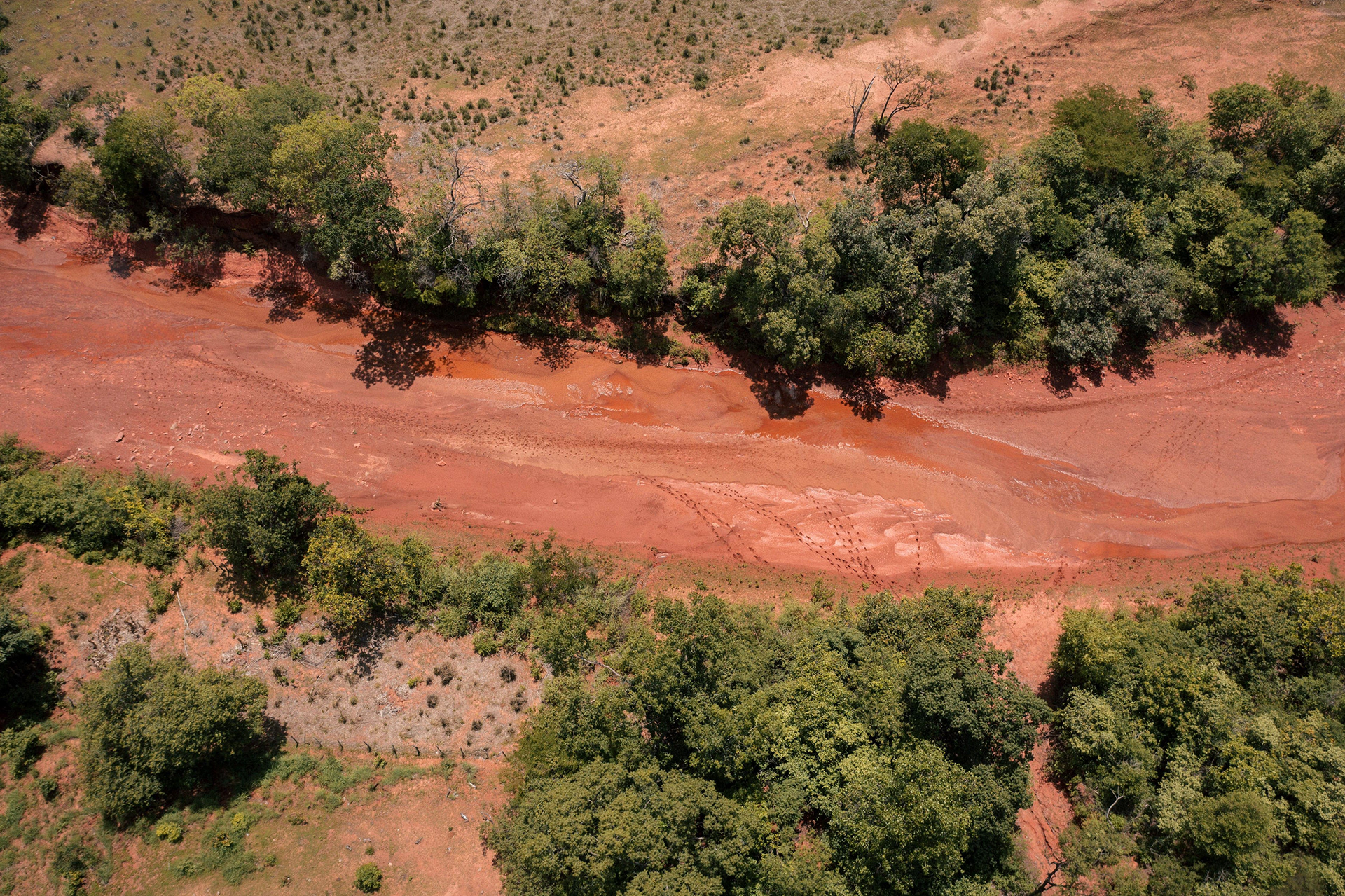 Vista aérea de terreno com manchas de erosão entre vegetação, Gilbués