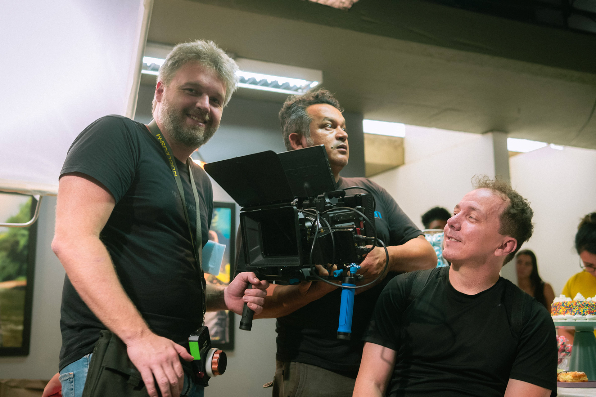 Dois homens da equipe atrás de equipamento de filmagem