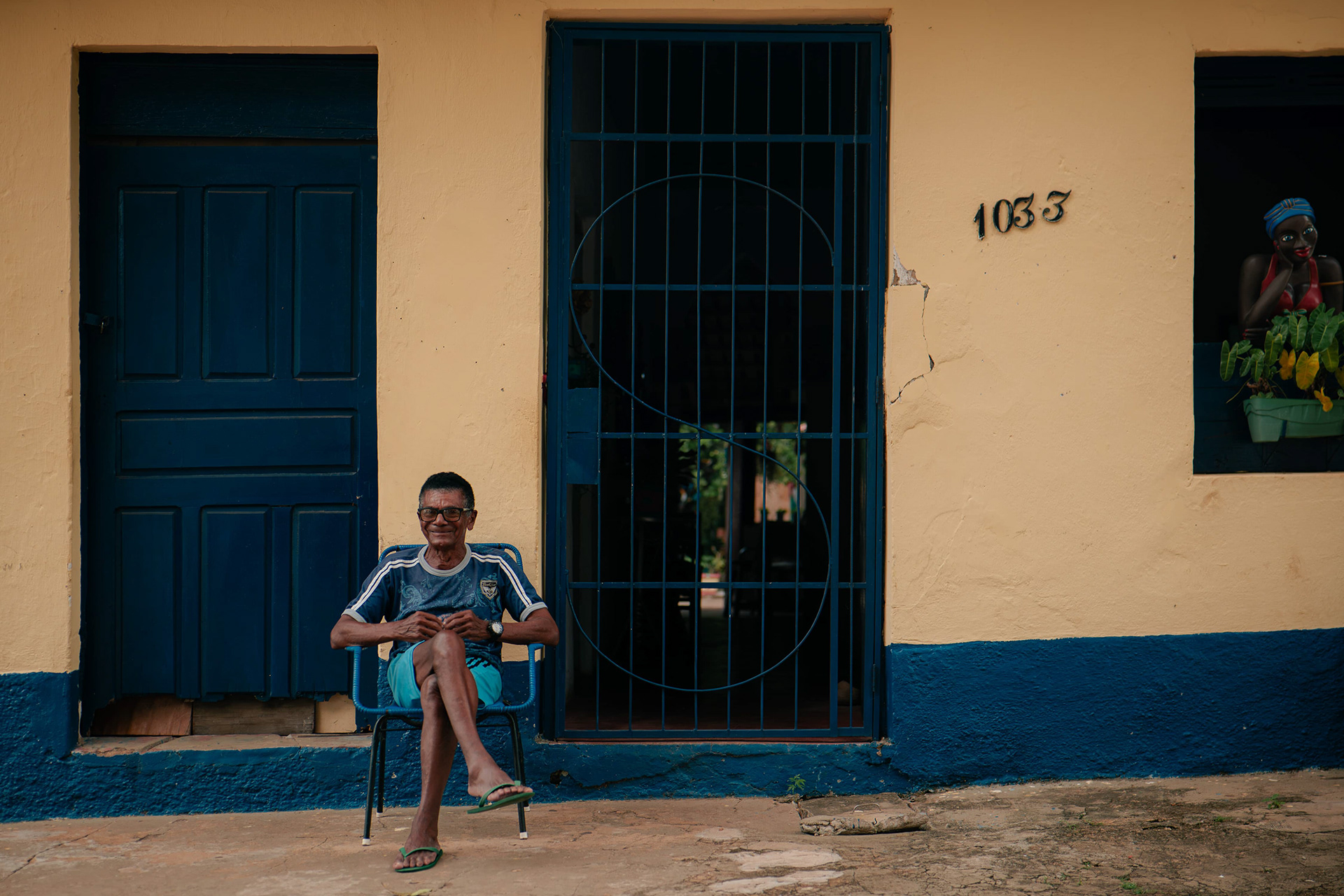 Retrato de homem em frente a casarão de janelas azuis, Maranhão