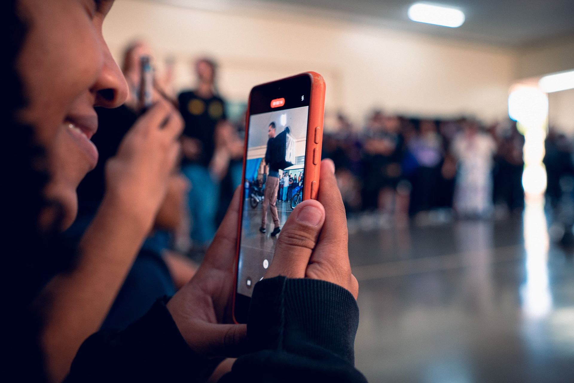 Espectador fotografando apresentação de dança urbana com celular