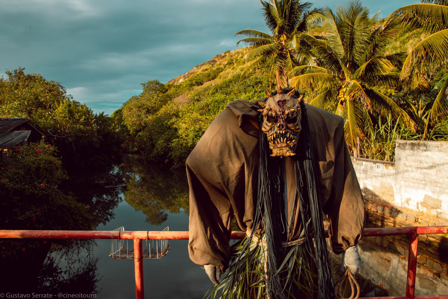 Figura mascarada caminhando por estrada durante ritual de carnaval
