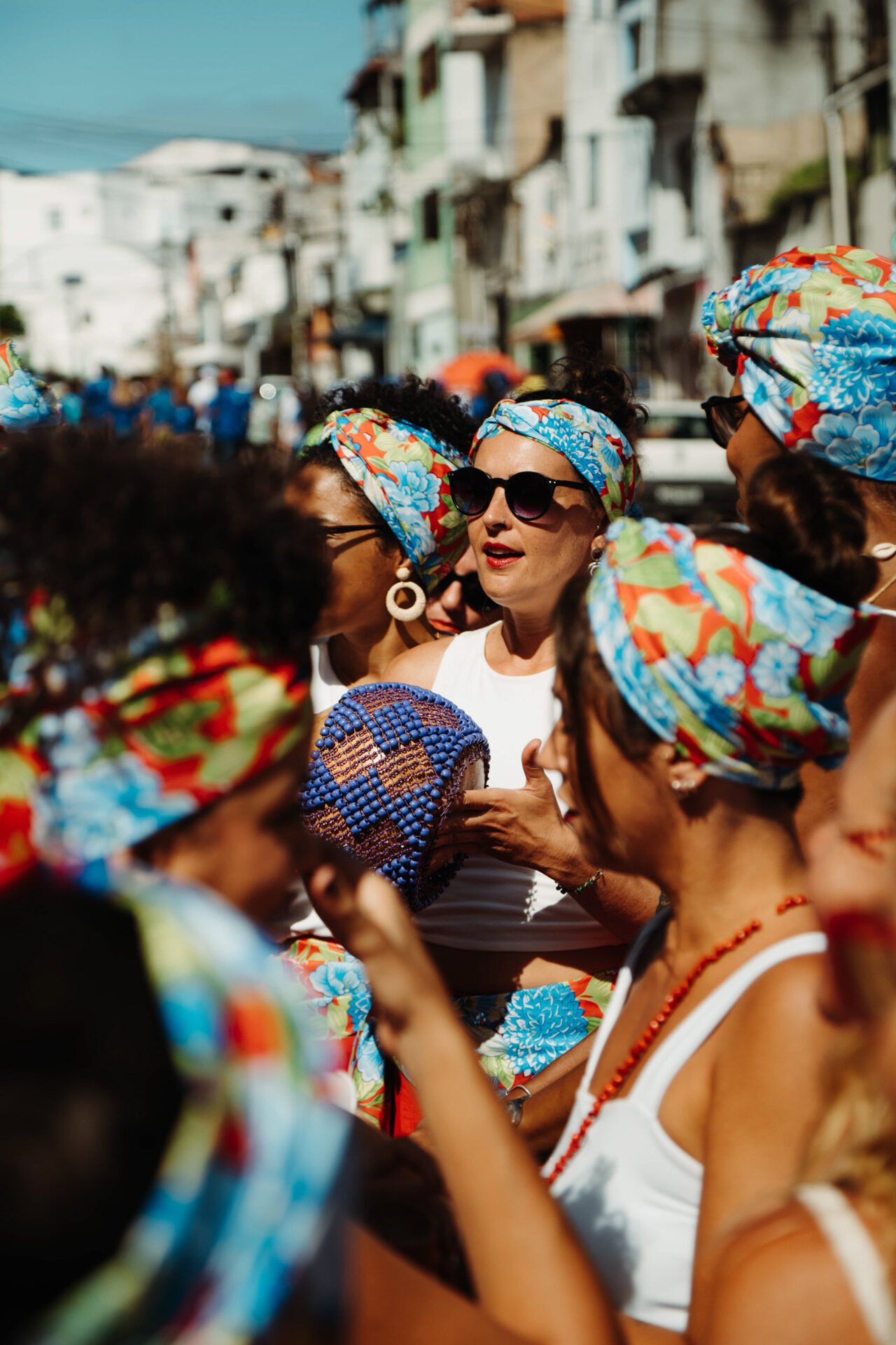 Mulher sorridente com turbante colorido em celebração baiana