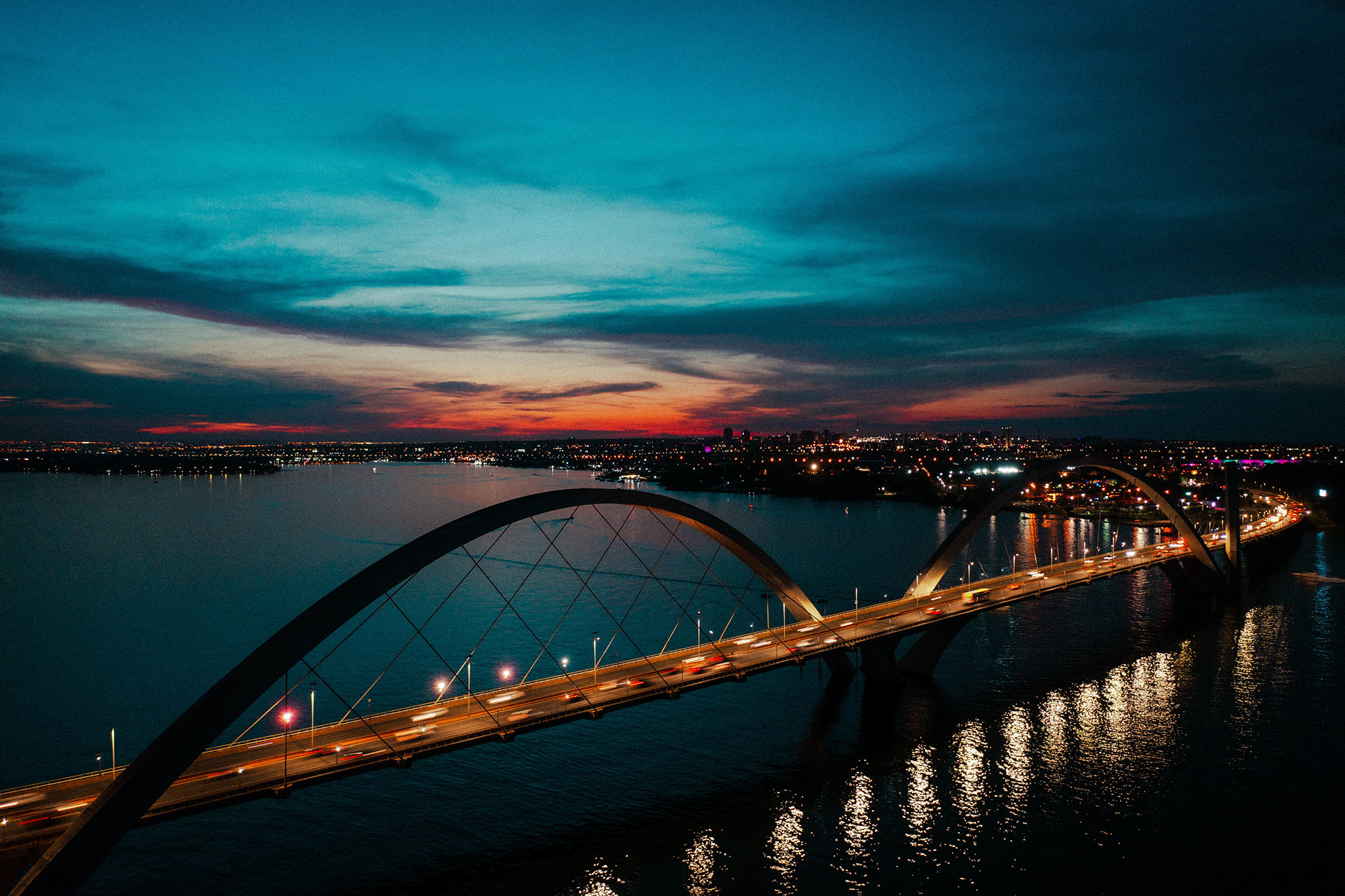 Ponte JK ao entardecer com céu em tons alaranjados, Brasília