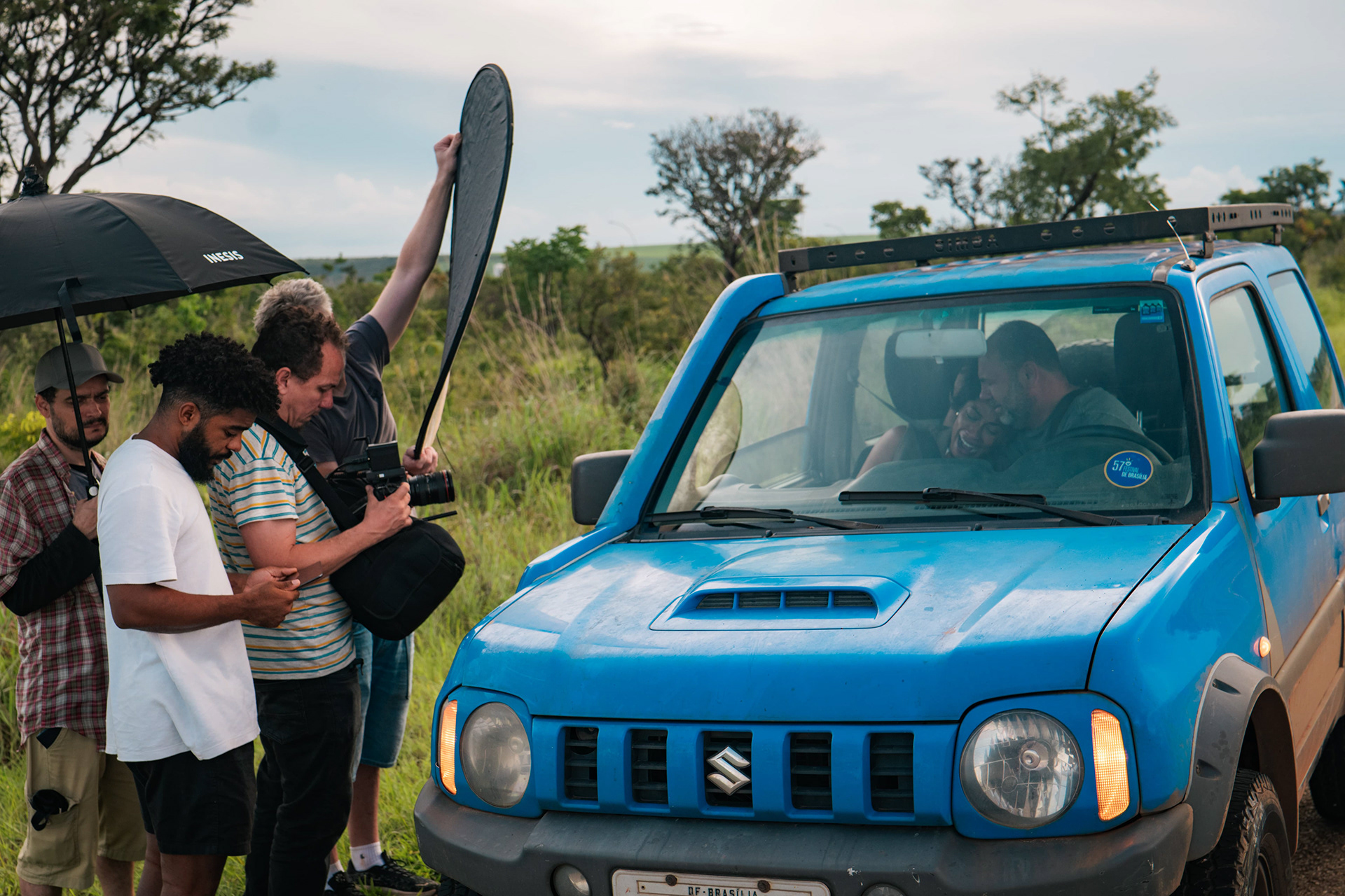 Cena com carro azul e mão em primeiro plano, making of