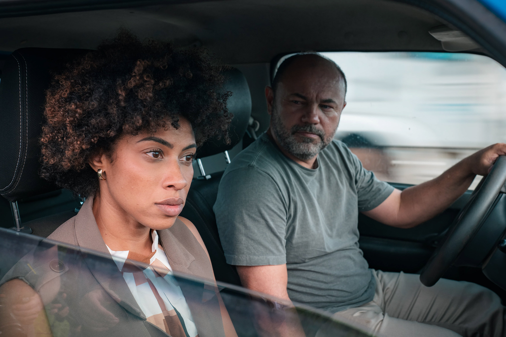 Dois homens em cena de carro durante gravação
