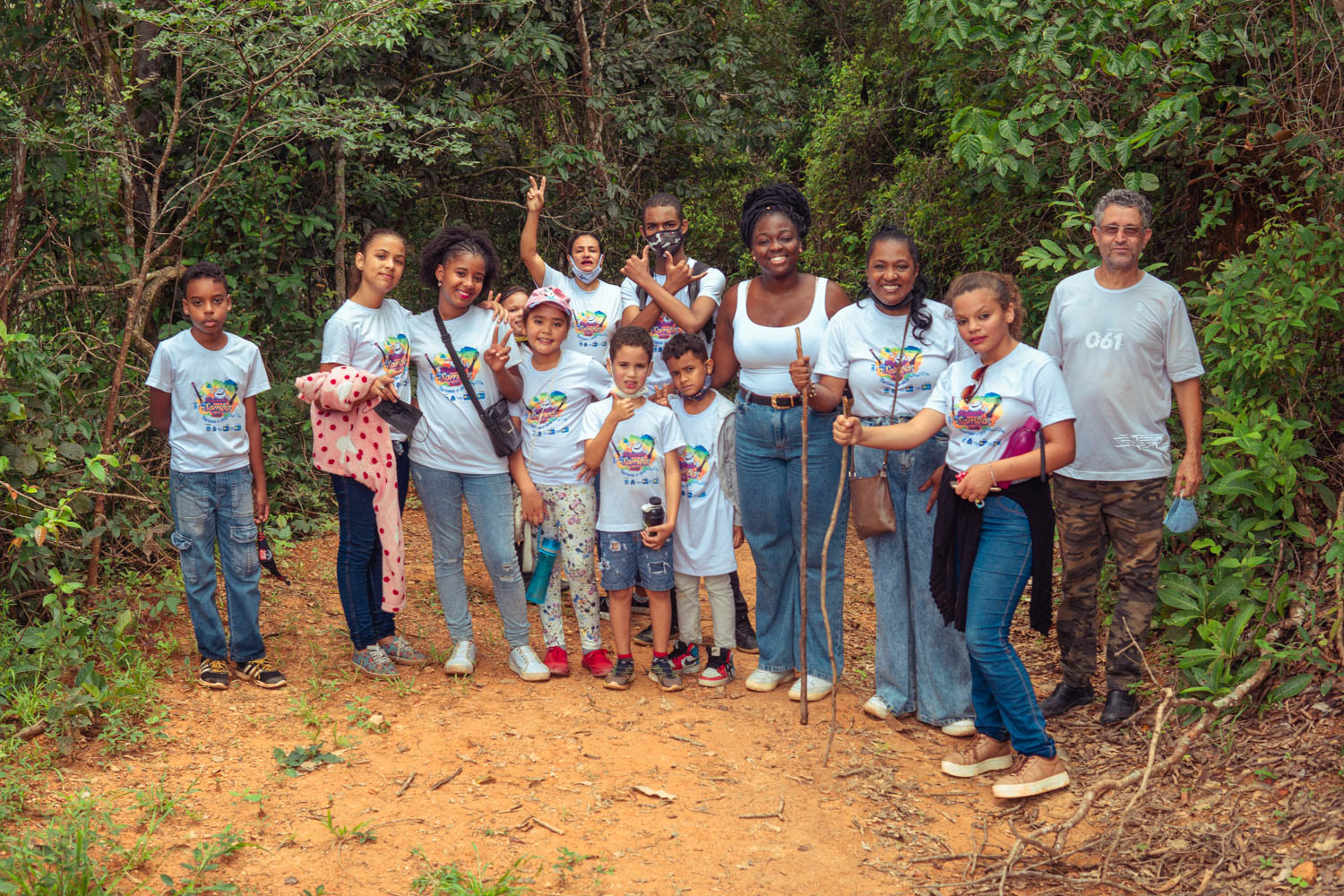 Grupo de crianças e adultos sorrindo em foto de projeto social